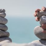 Hands stacking and balancing a stone tower, or cairn