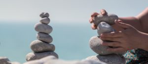 Hands stacking and balancing a stone tower, or cairn